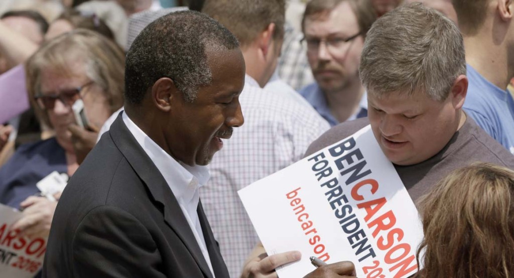 Republican presidential candidate Ben Carson autographs a campaign sign at a rally in Little Rock, Ark., Thursday, Aug. 27, 2015. (AP Photo/Danny Johnston)