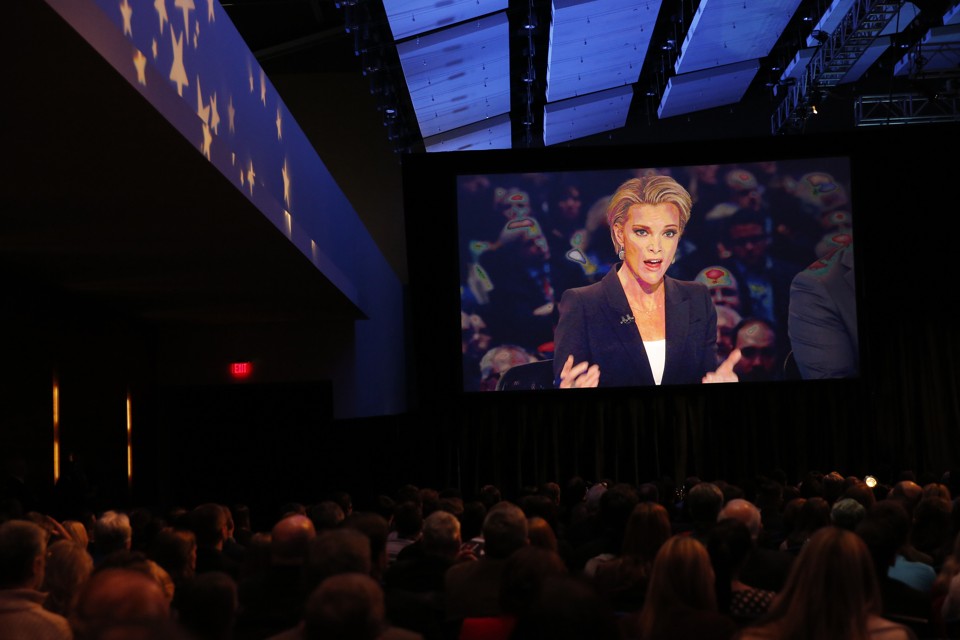 Fox News Channel anchor and debate moderator Megyn Kelly is seen on a video screen in the debate hall during the debate held by Fox News for the top 2016 U.S. Republican presidential candidates in Des Moines, Iowa January 28, 2015. REUTERS/Carlos Barria - RTX24HQ3