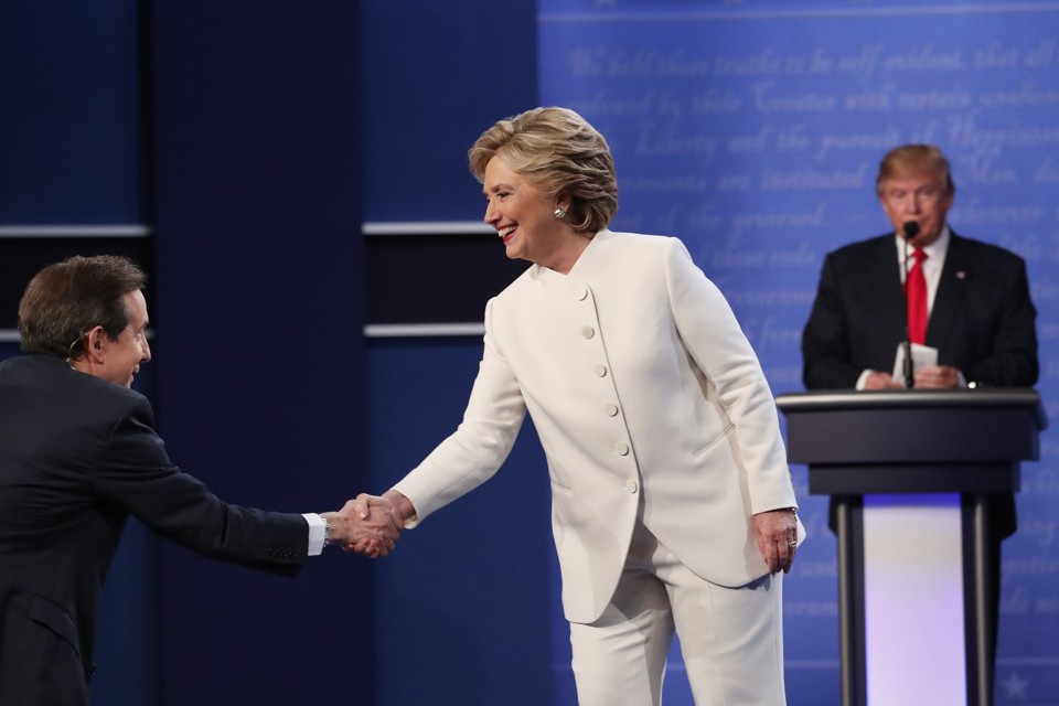 Democratic U.S. presidential nominee Hillary Clinton shakes hands with moderator Chris Wallace (L) as Republican U.S. presidential nominee Donald Trump remains at his podium after the conclusion of their third and final 2016 presidential campaign debate at UNLV in Las Vegas, Nevada, U.S., October 19, 2016. REUTERS/Rick Wilking - RTX2PM9J